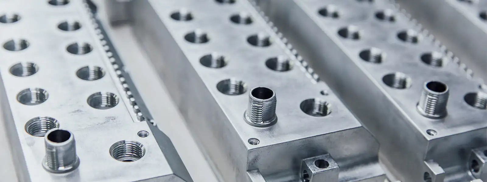 A row of metal plates with holes on them.